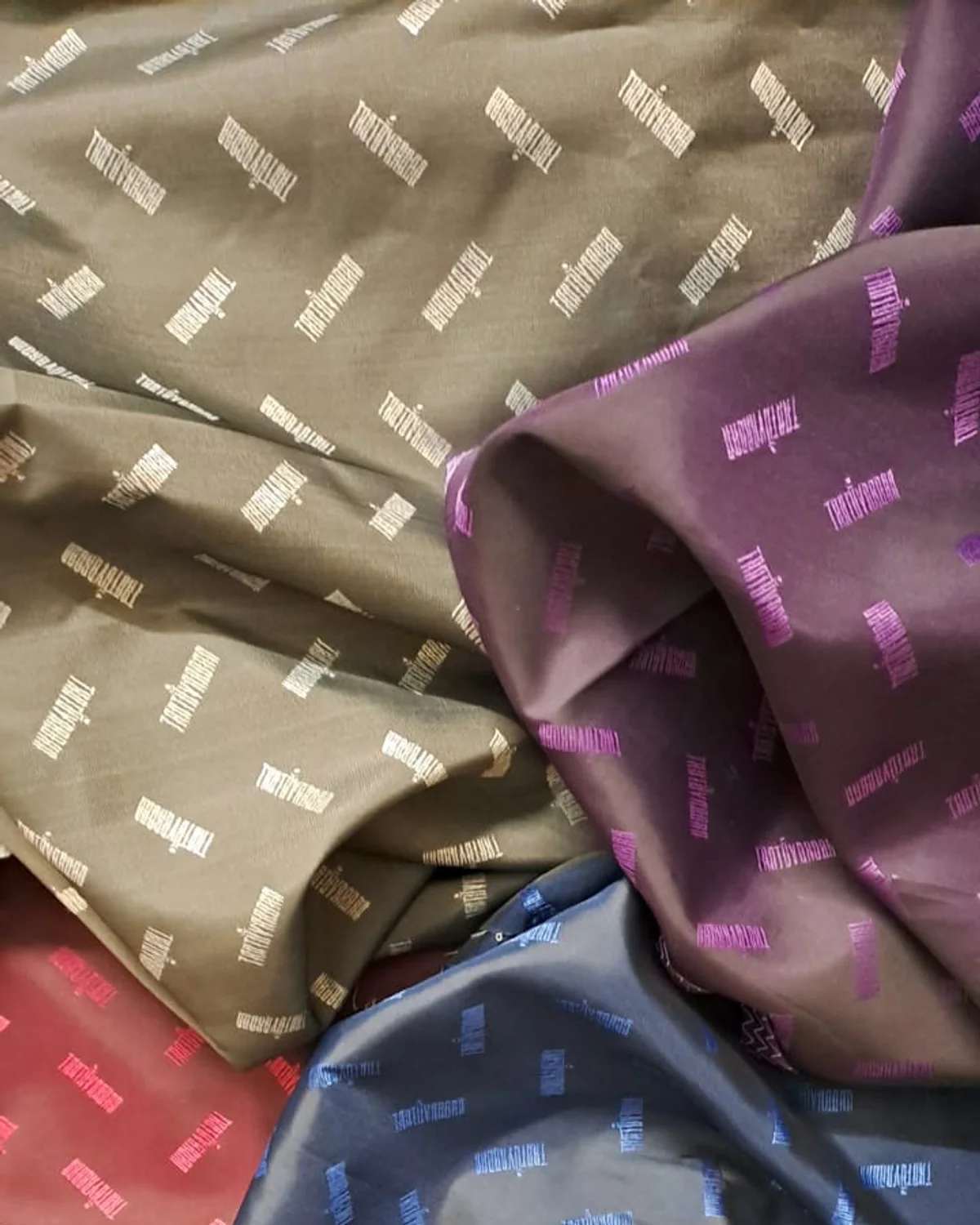 Assorted jacquard woven lining fabrics in refined bespoke tailoring colours